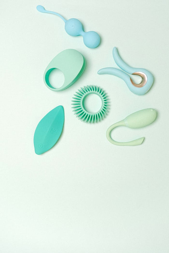 why-choose-us A variety of elegantly designed silicone sex toys on a soft pastel green background, showcasing modern minimalist aesthetics.